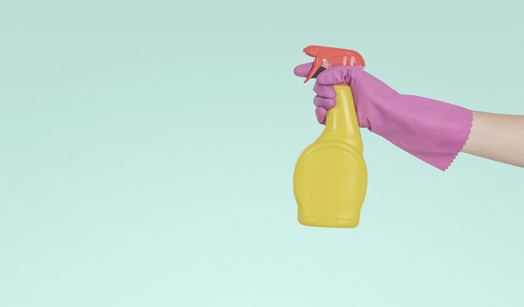Gloved hand holding a spray bottle