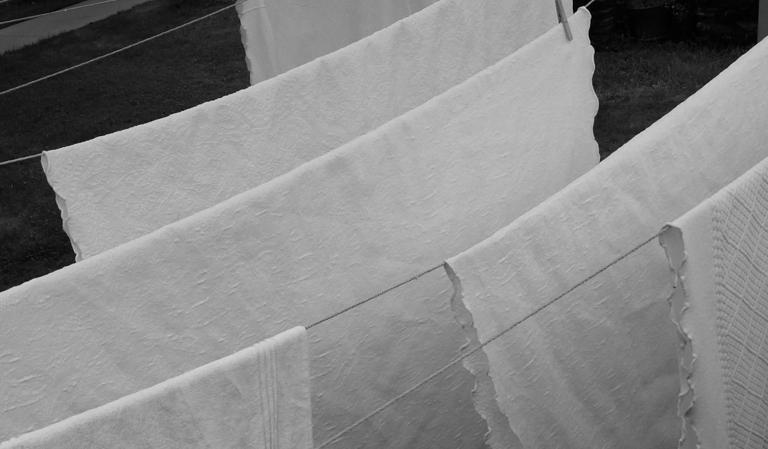 White flat sheets on a washing line.