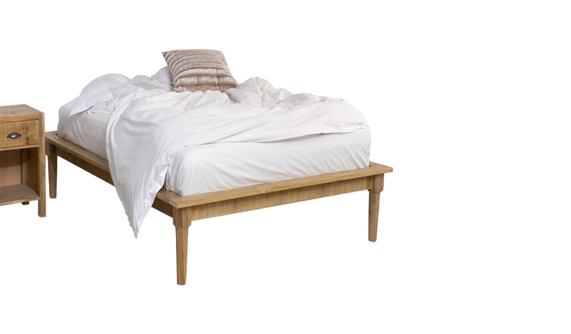 Low profile platform bed with plush white bedding and a wooden cabinet to the left of the bed.
